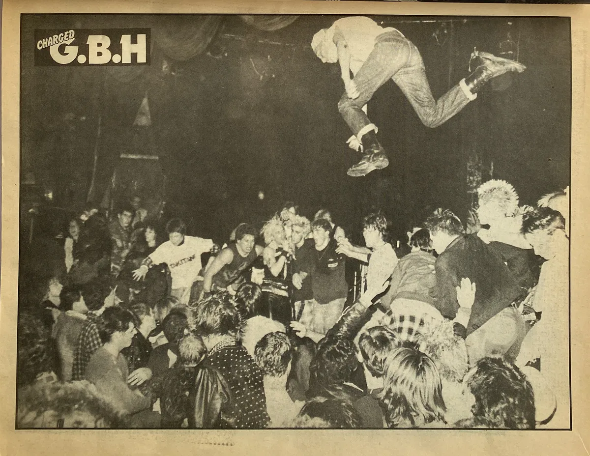 Imatge d'un concert de la banda punk GBH, on una persona està volant per sobre del públic després de llançar-se de l'escenari