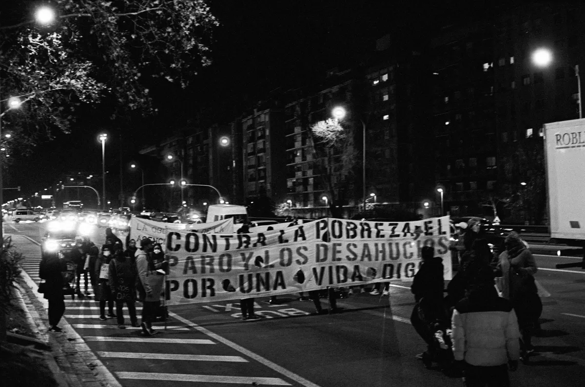 A protest in the Meridiana, one of the main entrances to the city of Barcelona. The protestors hold a big sign that says "Against poverty, unemployment and evictions, for a dignified life".